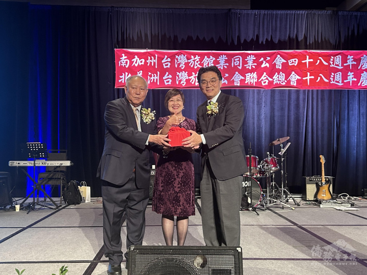 滿任總會長陳清亮 (左1)與新任總會長鄭吉成(右1)進行交接，由徐佳青見證