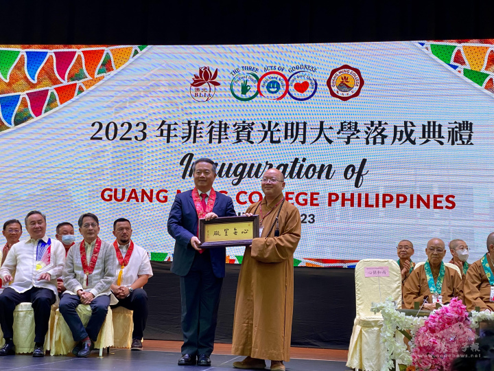 心保和尚〈右〉以星雲大師一筆字墨寶與大使周民淦〈左〉結緣