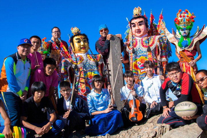 台南市金城國中校長蔡明昌（立者左）嘗試在校內成立傳統藝陣社團，透過專業師資傳授學生各種藝陣技巧，成功引領中輟學生回歸校園並踏上國際舞台，其用心也榮獲2023師鐸獎肯定。（蔡明昌提供）