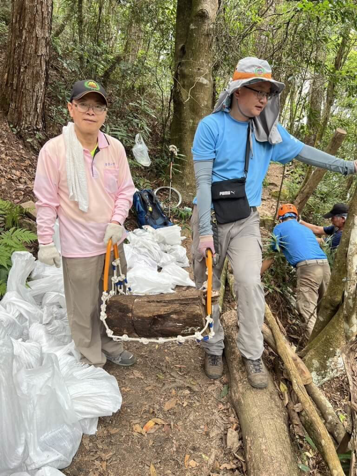 林務局東勢林區管理處攜手台中市山岳會、三信商業銀行舉辦東卯山步道手作維護活動，吸引30人參加，透過因地制宜、就地取材等生態工法進行，更號召山友「一人一袋」揹土石上山填補路面。（東勢林管處提供）