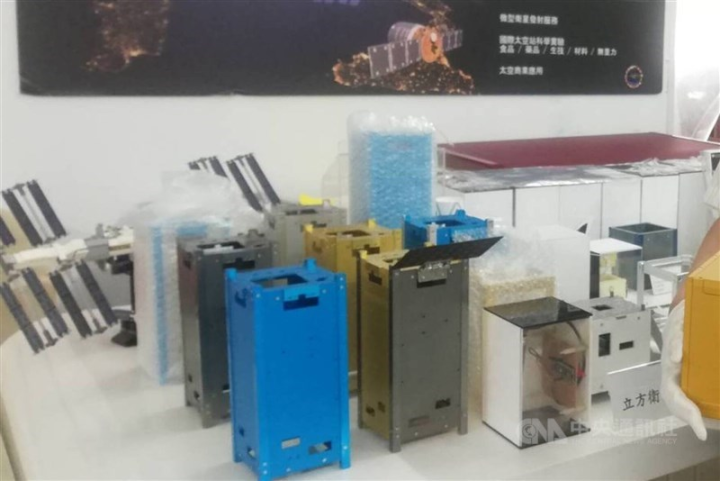 Various satellite models and components are displayed at a press event on May 21, 2023.