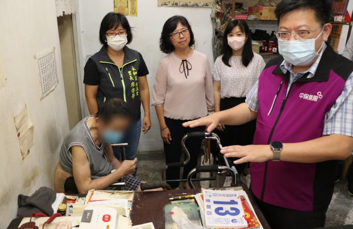 新北市社會局副局長許秀能（後左2）13日前往永和區關懷裝設智慧型緊急救援系統的獨居長輩；只要長輩長時間沒有活動，或在一個地方停留過久，系統就會自動發出警訊，啟動緊急救援。（新北市社會局提供）