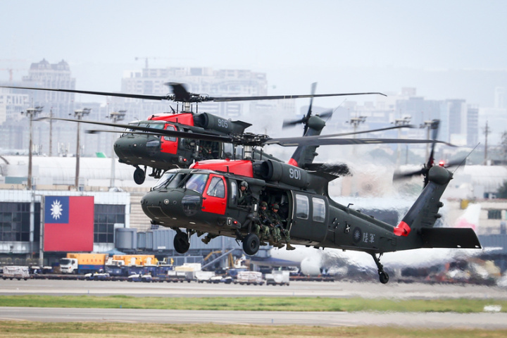 國軍漢光39號實兵演習26日進入第3天，首次於桃園國際機場展開反空機降操演，反空機降演練由陸軍航特部等部隊搭乘UH-60M黑鷹直升機擔任攻擊軍（紅軍），後方可見桃園機場的大型國旗。