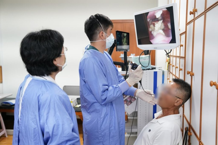 花蓮慈濟醫院復健醫學部主治醫師葉映廷（中）與語言治療師陳佳惠透過設備為病患檢查，找出吞嚥問題，並指導改善吞嚥動作。（花蓮慈濟醫院提供）