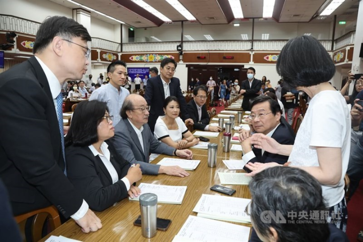 Democratic Progressive Party legislative caucus whip Ker Chien-ming (front third left) and Kuomintang legislative caucus whip Tseng Ming-chung (third right) discuss with other legislators at the Legislature in Taipei Monday. 
