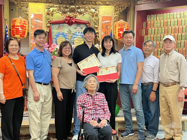 黃氏公所主席黃偉健(左二)和黃光沐(右一)，以及黃國瀚獎學金執行人 黃協建(右二)和黃國瀚夫人黃司徒秀華(前)，黃氏婦女部主任黃周麗桃 (左一)，聯袂頒發黃國瀚獎學金給黃俊文(後左四)、黃穎怡(後右四)。 他們的父母黃國源(右三)要英合影。