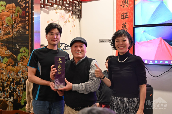 僑務顧問黃傳明(中)抽中由太紫執行長盧如尚(左)贊助的太紫高粱酒