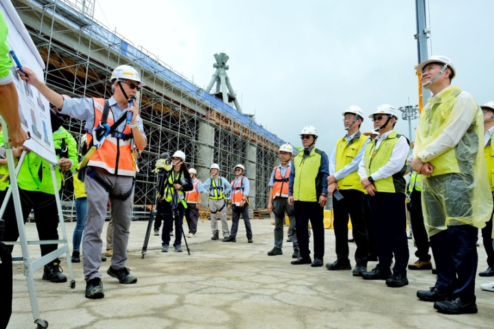 桃園國際機場公司董事長楊偉甫（黃衣右2）2日與總經理范孝倫（黃衣右3）等人前往第3航站區主體航廈工區視察第一支屋頂結構巨柱組立作業，聽取相關簡報。