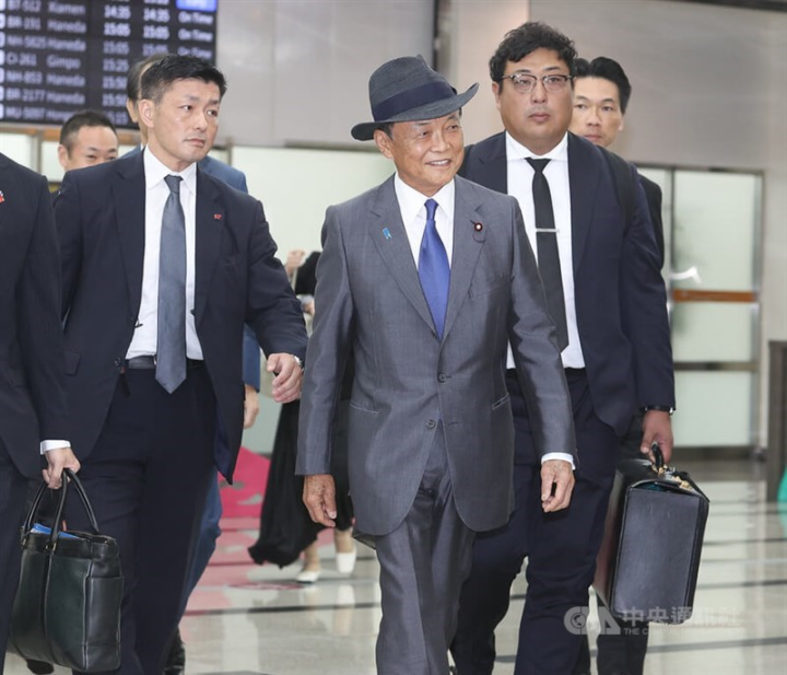 Taro Aso (front center), former Japanese prime minister, arrives at Taipei Songshan Airport Monday.