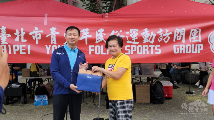 臺北市教育局副局長鄧進權代表訪問團特地送紀念品給余麗媖，感謝她安排場地、道具
