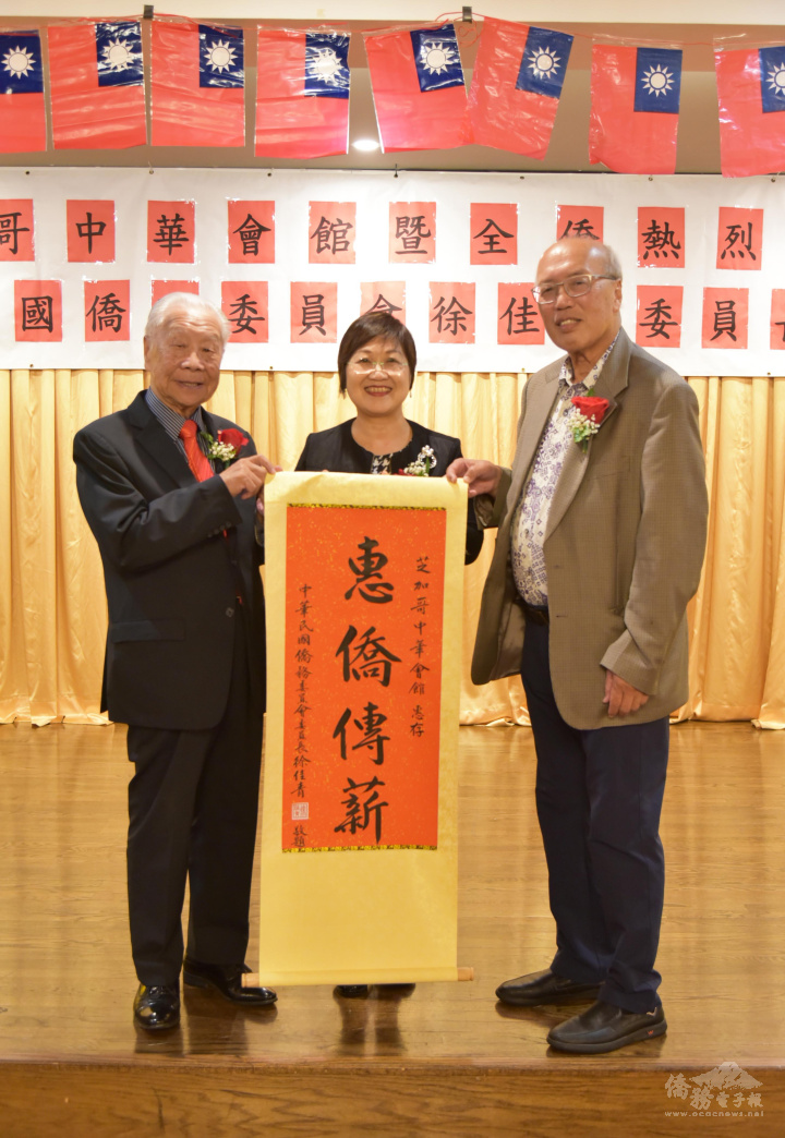 徐佳青致贈「惠僑傳薪」掛軸，由伍健生、陳達偉代表接受