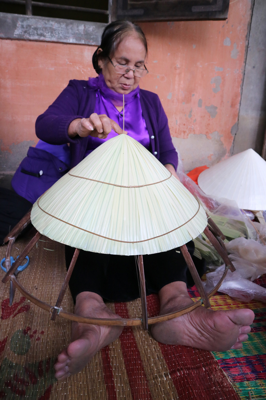 65歲的阮氏茉（圖）是土生土長的中部人，從小就和長輩學做斗笠，一做就是50幾年。她說，越南斗笠要做得好、做得漂亮，決勝的關鍵就是「封頂」，一定要讓斗笠的帽頂呈現尖挺狀。