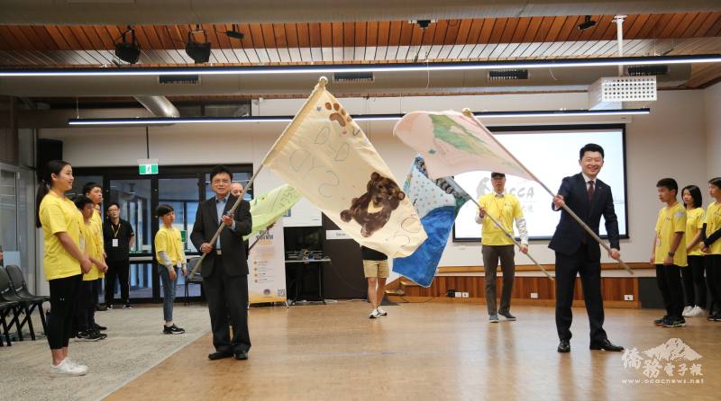 吳正偉、文教中心主任施博祥、僑務委員林栢梧、僑務委員葉義深揮舞小隊隊旗後進行授旗