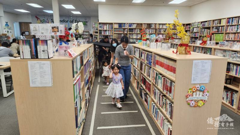 志工媽媽使用紙膠帶在圖書館內貼上火車鐵軌以及行車動線，還用黑布在書架間搭建山洞