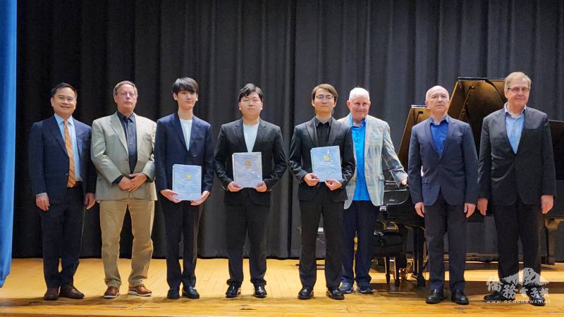 傅聰國際協奏曲比賽評審和3名優勝者合影。