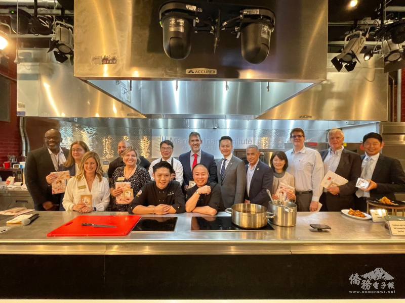 Two chefs posing for a photo with some of the guests (Photo Credit: TECO in Miami).