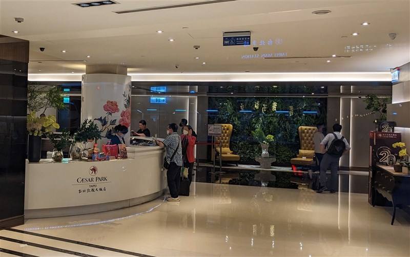 Guests speak to a receptionist at a tourist hotel in Taipei.