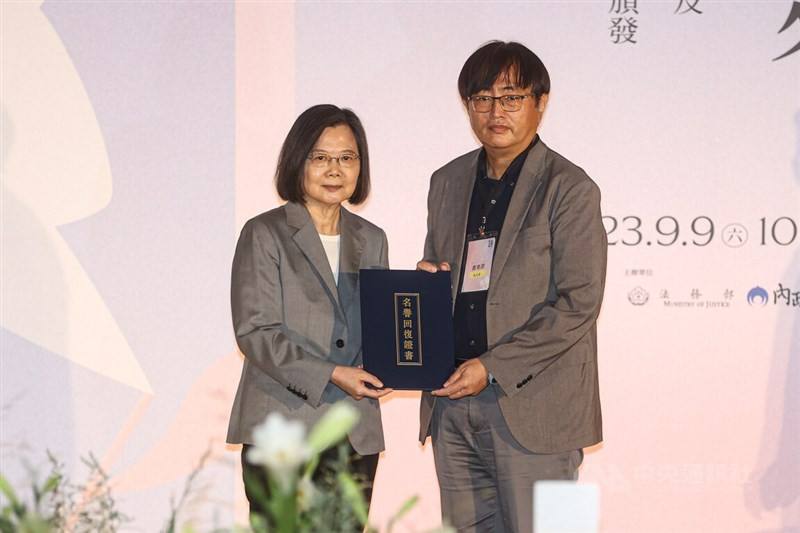 President Tsai Ing-wen (left) presents the certificate of exoneration of recently deceased former "White Terror" era political prisoner Tsai Kun-lin to the latter's son, mathematics professor Tsai Yen-lung (right), at a ceremony in Taipei Saturday.