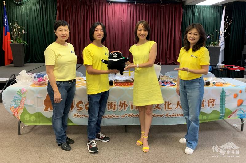 FASCA橙縣分會青年文化大使林宇安(左二)在112年度洛杉磯新生培訓結業式代表致詞表現優異，僑務委員張珮鑾(右二)致贈黑熊頸枕予以表揚。左一為諮詢導師何佳琪、右一為諮詢導師廖美惠