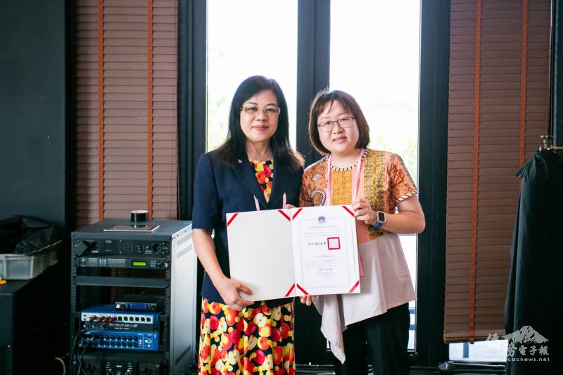 僑務組組長李叔玲頒發印尼青商張又于「全球青商潛力之星」證書，由其胞妹代為受頒