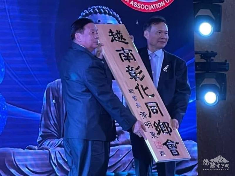 創會理事長張慶煌從世界彰化同鄉總會長黃東明手中接下越南彰化同鄉會牌匾