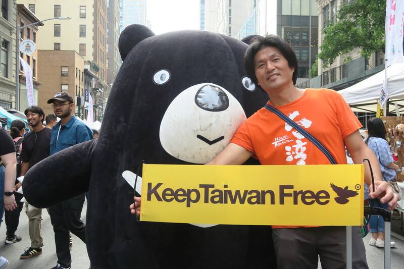 紐約台灣市集總策畫許伯丞17日在台灣黑熊吉祥物前舉Keep Taiwan Free（守護台灣自由）標語，傳達台灣加入聯合國訴求。
