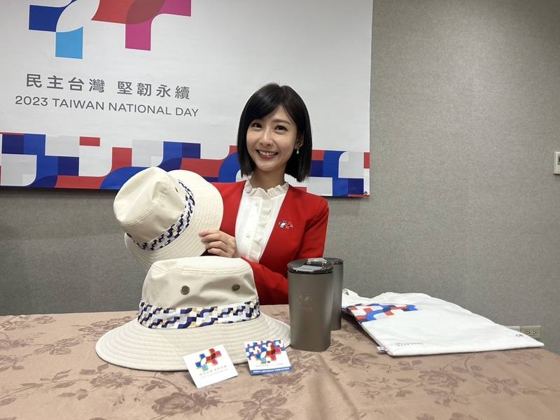 112年國慶大會國慶大會主持人之一的莊惠琪展示今年國慶大會禮賓紀念品，包含國慶徽章、超輕純鈦杯等台灣製造商品。