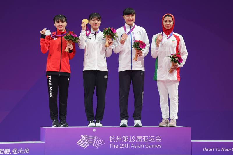 杭州亞運24日進行跆拳道品勢項目，台灣選手馬允中摘銀、陳歆雅（右2）奪銅，刷新上一屆成績。圖為陳歆雅在頒獎典禮上與得牌選手合影留念。