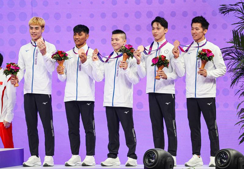 台灣體操男團24日在杭州亞運競技體操男團決賽奪得銅牌，締造隊史新頁。圖為台灣隊在頒獎典禮上舉起獎牌合影。