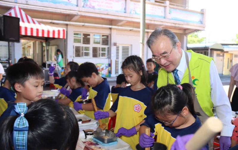 農業部農糧署推動將節氣融入食米教育，25日在宜蘭縣冬山鄉順安國小舉辦活動，農糧署長胡忠一（右後，黃背心者）和學童一同體驗創意搗麻糬。（農業部農糧署提供）