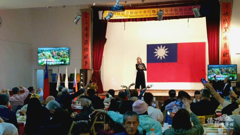 阿根廷臺灣僑民聯合會中秋晚宴參與鄉親接力高歌，僑委會文化訪問團舞鈴劇場成員獻唱《月亮代表我的心》，臺下民眾也點亮手機手電筒，營造星海一起同樂，現場氣氛溫馨。