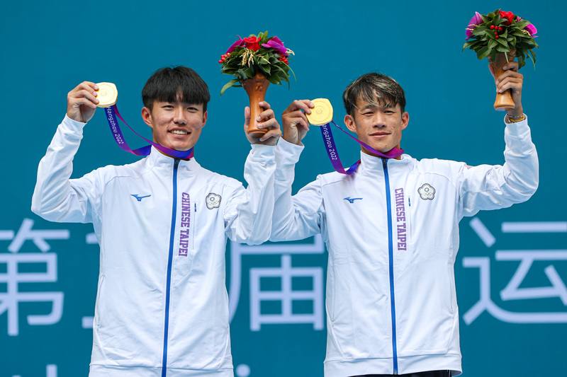 台灣網球選手許育修（右）、莊吉生（左）29日在杭州亞運網球男子雙打項目奪冠，兩人開心咬金牌慶祝勝利。