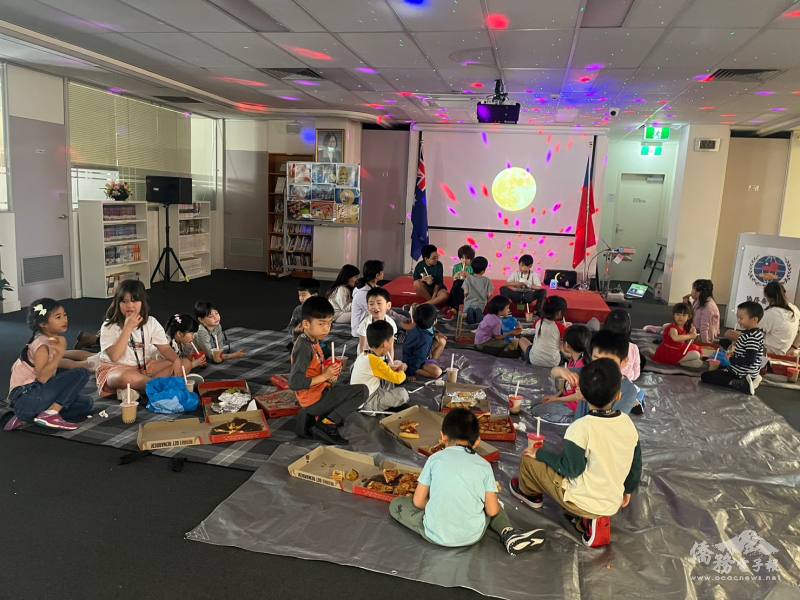 學生席地而坐吃披薩賞月