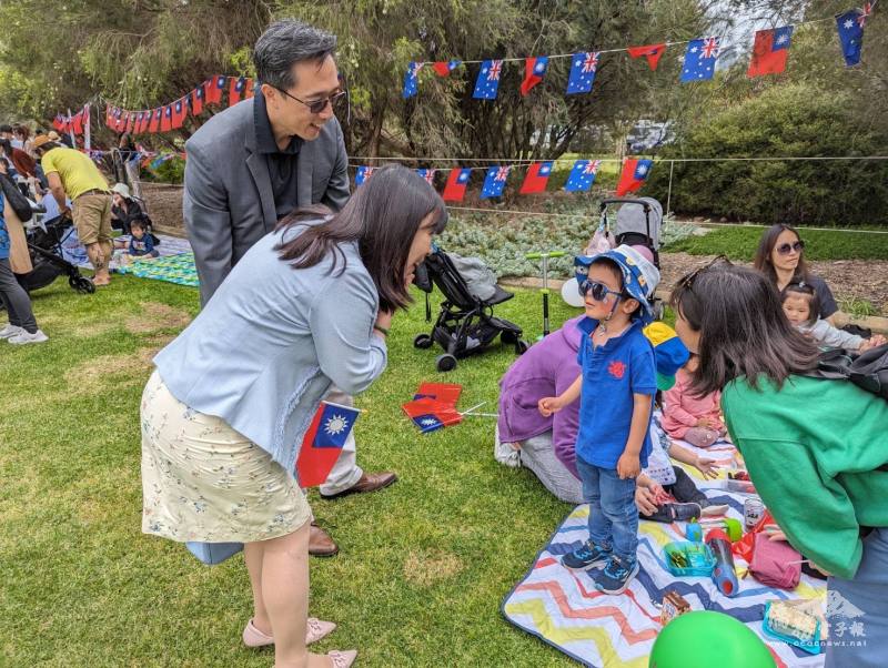 徐佑典夫婦與參加升旗的小朋友親切互動