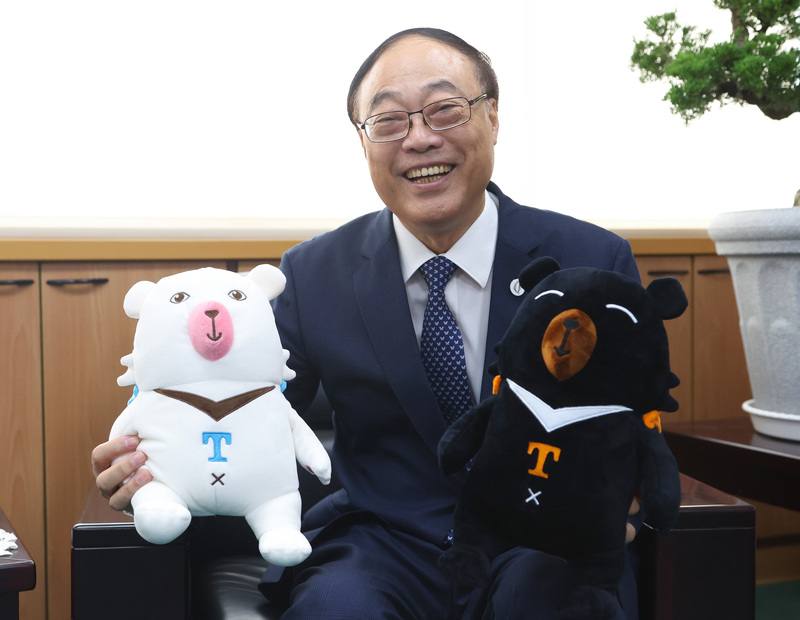 交通部觀光署長周永暉日前接受中央社專訪時指出，國旅和國外來台旅客應該分眾化處理，推出不同吸客策略。圖為周永暉持台灣觀光吉祥物「喔熊」（黑）及「嗨熊」（左）玩偶開心留影。