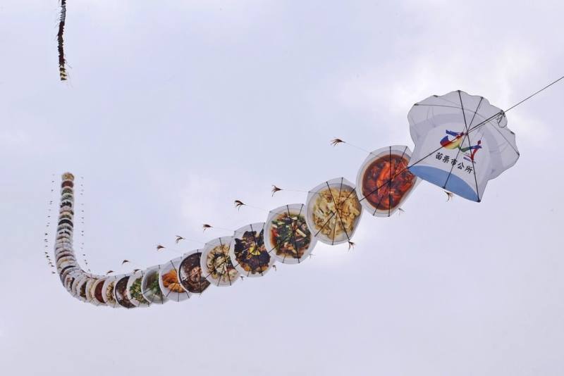 2023苗栗風箏文化暨客家美食節28、29日將在苗栗市河濱公園登場，20日搶先試飛長約72公尺的客家宴客料理串聯風箏為活動暖身。（苗栗市公所提供）