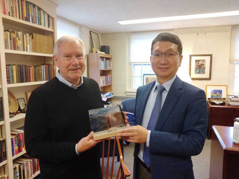 國立中山大學國際長周明奇（右）2023年回訪美國明德學院，贈禮給明德學院教務長暨語言學院院長史奈德（Stephen Snyder）（左）。兩校交流促成結盟，簽署合作備忘錄，共同成立台灣第一所「台灣明德學校」（中山大學提供）