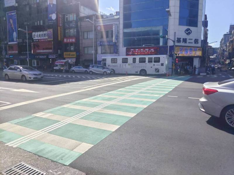 基隆市二信循環站前方的「綠色行人穿越道」（綠色斑馬線）上多出3條白線，原來是市政府劃設的「導盲行穿線」，除高度增加0.4公分，防滑係數也同步升級。（基隆市政府提供）