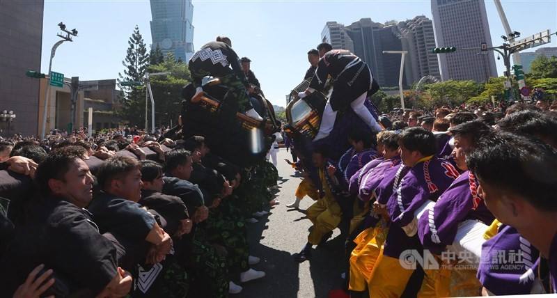 Two Japanese shrines mounted on palanquins clash into each other in front of the Taipei City Hall Sunday.