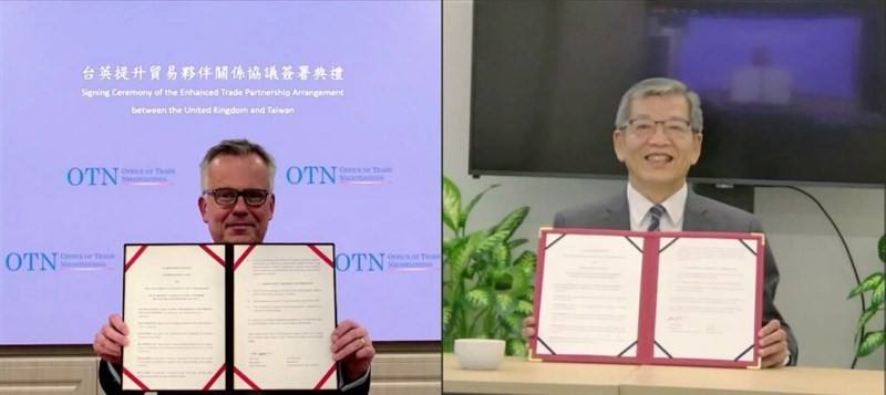 John Dennis (left), head of the British Office Taipei and Kelly Hsieh, the Taiwan's Representative to the United Kingdom show the newly signed Enhanced Trade Partnership in Taipei and London, respectively, on Wednesday. Photo courtesy of Executive Yuan No