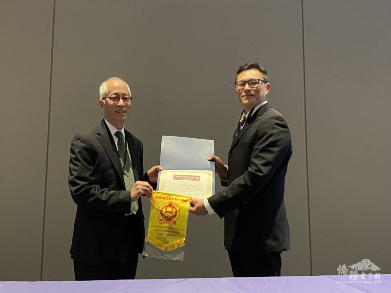 全美中文學校聯合總會總會長林志嘉（右）頒贈獎狀和旗幟給伊州教育委員會主席史提夫伊索耶博士