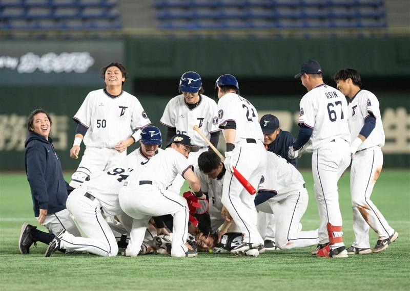 Taiwan players gather around Kuo Tien-hsin (on the ground) to celebrate the 4-3 walk-off victory over Australia at the Tokyo Dome Sunday. Photo taken from Wei Chuan Dragons' Facebook page