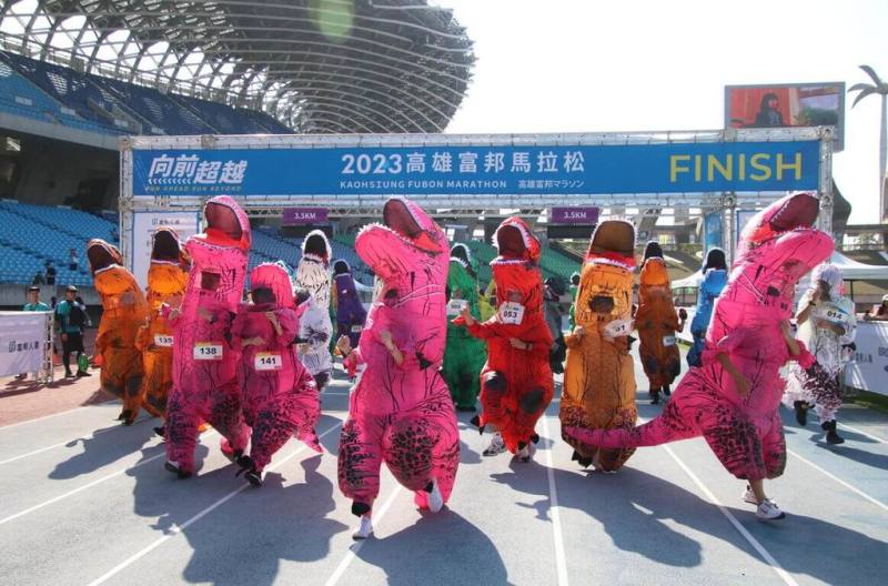 2023高雄富邦馬拉松25日開跑，此次亮點是恐龍變裝競速賽，民眾穿著充氣恐龍裝在國家體育場田徑場狂奔，相當吸睛。（高雄市運發局提供）
