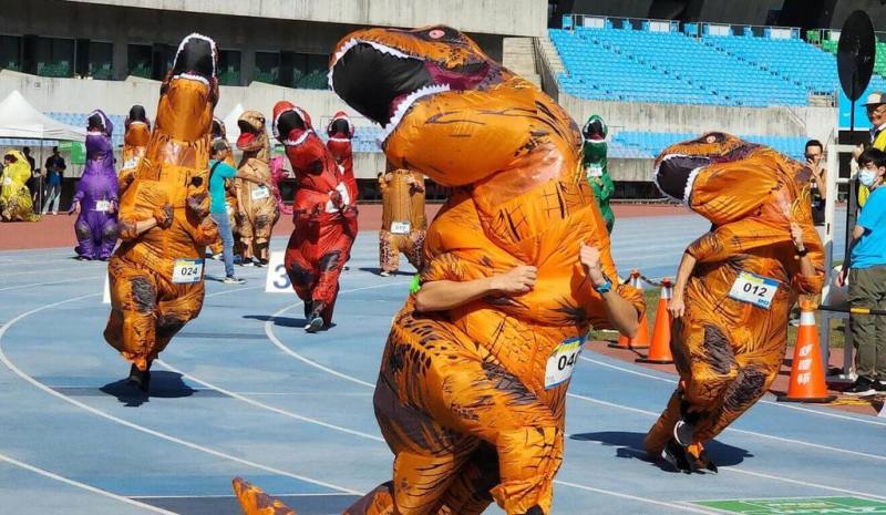 2023高雄富邦馬拉松25日登場，此次亮點是恐龍變裝競速賽，參賽者穿著自行準備的恐龍裝，在國家田徑場上衝刺狂奔，不只比速度更比搶鏡。（高雄市運發局提供）