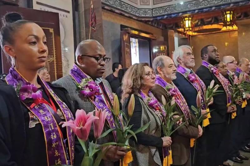 宜蘭縣五結鄉聖清宮28日舉辦宮慶，16國使節代表們進入宮廟大殿，手持鮮花向神明致意。（讀者提供）