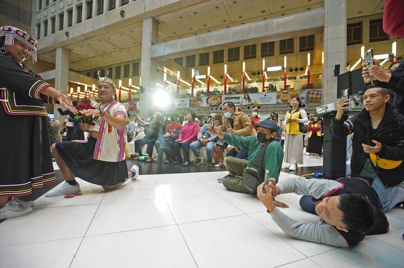 台灣鐵路管理局職工福利委員會2日在台北車站熱鬧舉辦「112年台鐵集團結婚典禮」，共有24對佳偶互許終身，其中布農族新人馬志豪（左2）下跪求婚時，親友們也在旁賣力搶拍，捕捉幸福時刻。