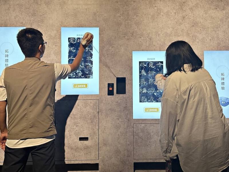 國立故宮博物院南部院區10月起推出常設展「揮翰學書－書法跨域新媒體展」，邀請民眾透過數位科技體驗書法藝術，展場也安排了數位拓碑體驗，吸引民眾參與。（故宮南院提供）