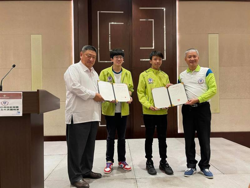 圖一：駐杜拜辦事處張治平處長(左一)將總統、副總統賀電交予勞動部勞動力發展署蔡孟良署長(右一)及代表隊選手代表。