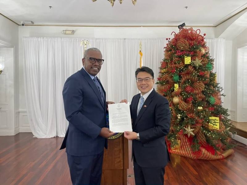 駐邁阿密辦事處處長周啟宇（右）代表接受美屬維京群島總督布萊恩（左）將支持台灣參與國際與訂定12月8日為台灣日賀狀。（邁阿密辦事處提供）