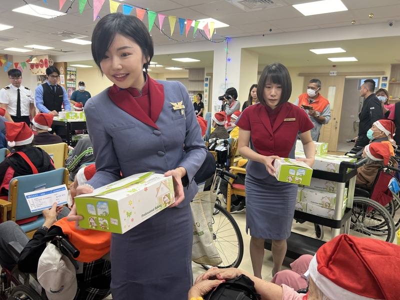 華信航空與一粒麥子基金會攜手，14日首度到台東市新生日照中心舉辦虛擬客艙之旅，空服員推著餐車逐一送上餐盒，讓長者們體驗或回憶搭乘飛機的美好時光。